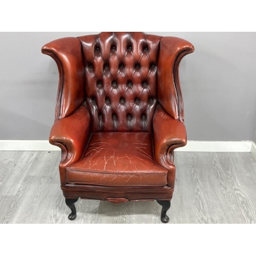 371 - Red leather metal studded wing back fireside armchair