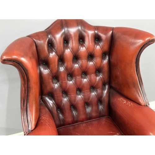 371 - Red leather metal studded wing back fireside armchair