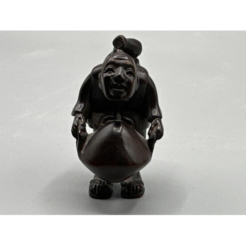 194 - Japanese hand carved Netsuke in the form of a villager, signed on base, H4cm