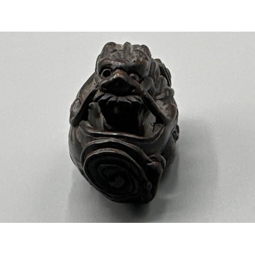 196 - Japanese hand carved boxwood Netsuke in the form of a Foo Dragon, signed on base, L6cm x H3.5cm