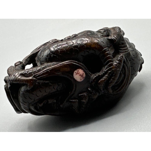 196 - Japanese hand carved boxwood Netsuke in the form of a Foo Dragon, signed on base, L6cm x H3.5cm