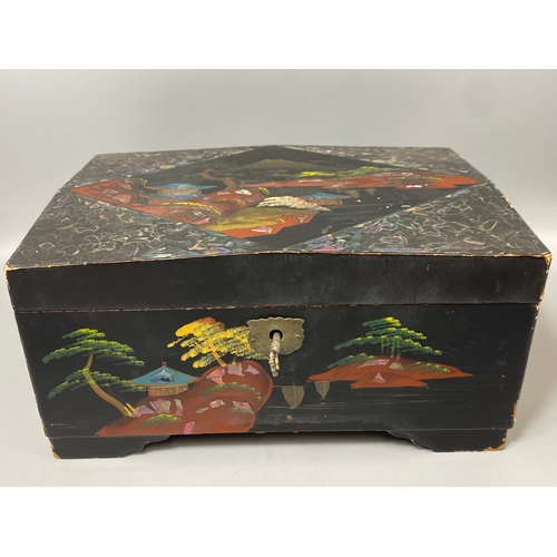 144 - Japanese black lacquer jewellery box which includes musical chimes