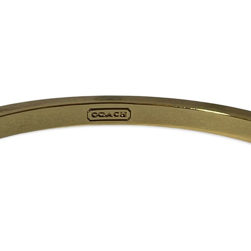 10 - Pair of bangles by Coach, one gold tone and the other rose, weighing 73.3 grams collectively