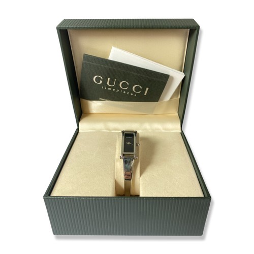 134 - Gucci 1500 L ladies watch with black face and stainless steel band complete with original box and pa... 