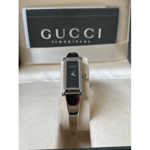 134 - Gucci 1500 L ladies watch with black face and stainless steel band complete with original box and pa... 