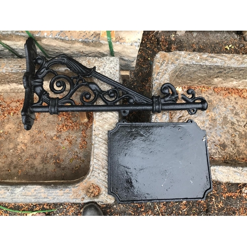 64 - CAST IRON LARGE HEAVY SWINGING SIGN ON WALL BRACKET