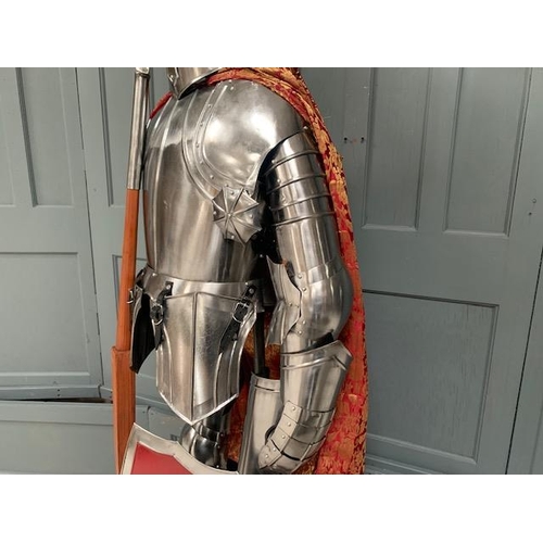 96 - HUGE MEDIEVAL DECORATIVE SUIT OF ARMOUR IN POLISHED STEEL WITH WITH SHIELD IN RED ROBE