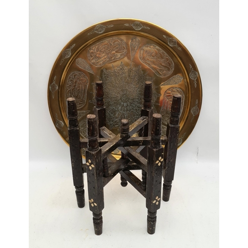 192 - North African Brass Chased Engraved Folding Table on Turned and Carved Black Wooden Legs. Measures 1... 