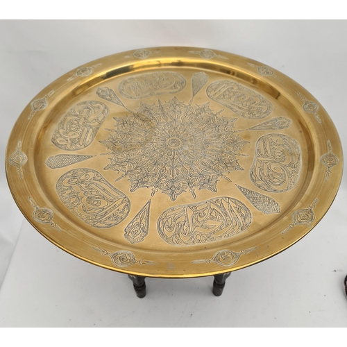 192 - North African Brass Chased Engraved Folding Table on Turned and Carved Black Wooden Legs. Measures 1... 