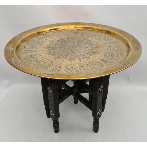 221 - North African Brass Chased Engraved Folding Table on Turned and Carved Black Wooden Legs. Measures 1... 