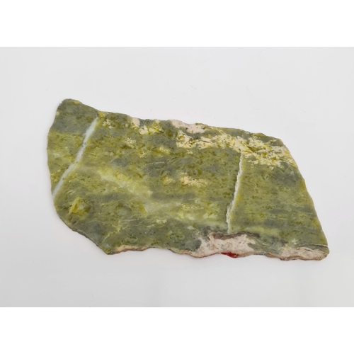 413 - Collectable Rocks and Minerals. Jadeite Slice. Total Weight 95g Measures 6 inches by 3 inches and 3/... 