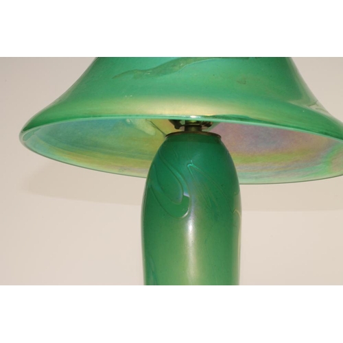 106 - J. DITCHFIELD - a glass electric table lamp base, the green iridescent high mushroom shade on a roun... 