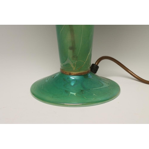 106 - J. DITCHFIELD - a glass electric table lamp base, the green iridescent high mushroom shade on a roun... 