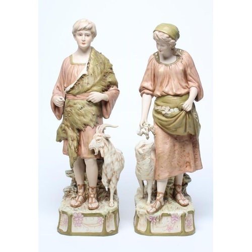 54 - A LARGE PAIR OF ROYAL DUX BISQUE PORCELAIN FIGURES, early 20th century, modelled as a young goatherd... 