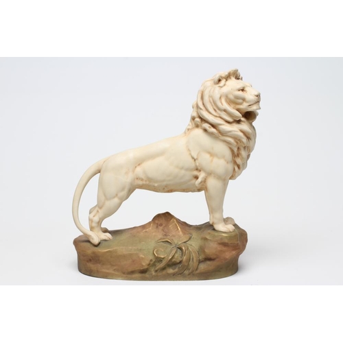 55 - A ROYAL DUX BISQUE PORCELAIN LION, early 20th century, modelled standing on a rocky outcrop, pink pa... 