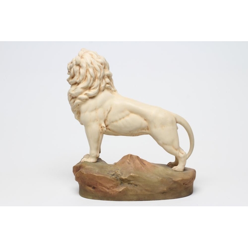 55 - A ROYAL DUX BISQUE PORCELAIN LION, early 20th century, modelled standing on a rocky outcrop, pink pa... 