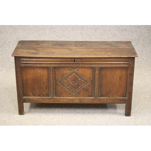 744 - AN OAK PANELLED COFFER, c.1700, the hinged moulded edged plank lid with chip end carving opening to ... 