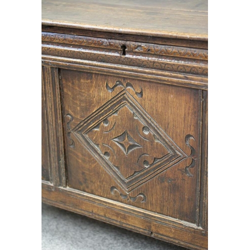 744 - AN OAK PANELLED COFFER, c.1700, the hinged moulded edged plank lid with chip end carving opening to ... 