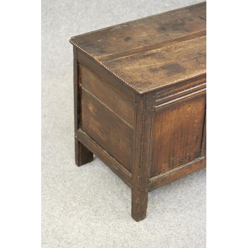 744 - AN OAK PANELLED COFFER, c.1700, the hinged moulded edged plank lid with chip end carving opening to ... 