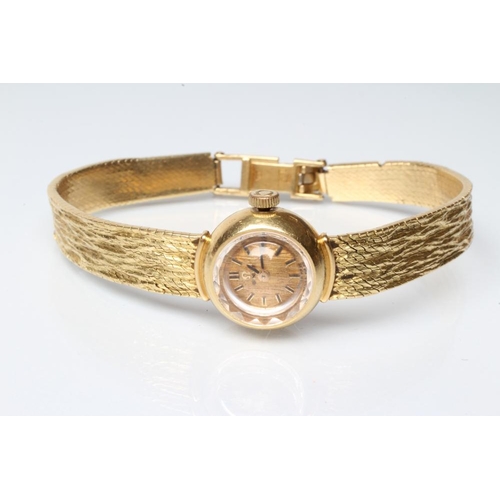 150 - A LADY'S 18CT GOLD OMEGA WRISTWATCH, the brushed gilt dial with applied metal batons, the seventeen ... 