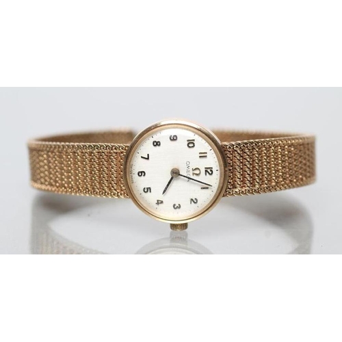 154 - A LADY'S 9CT GOLD OMEGA WRISTWATCH, the silvered dial with black Arabic numerals, in a plain case on... 
