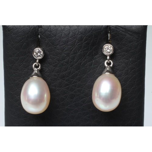 163 - A PAIR OF PEARL DROP EARRINGS, the oval pearls with white gold caps pendant from a solitaire diamond... 