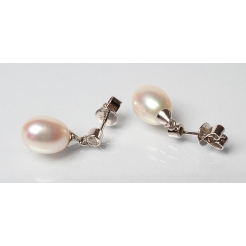 163 - A PAIR OF PEARL DROP EARRINGS, the oval pearls with white gold caps pendant from a solitaire diamond... 