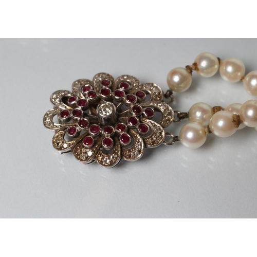 167 - A TRIPLE STRAND CULTURED PEARL NECKLACE, the knotted pearls set to an unmarked white metal open flow... 