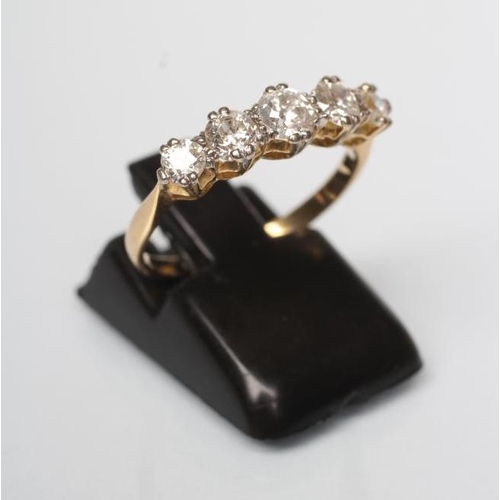 168 - A FIVE STONE DIAMOND RING, the graduated brilliant cut stones claw set to a plain shank stamped 18ct... 