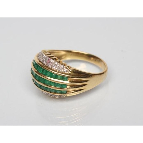 169 - AN EMERALD AND DIAMOND COCKTAIL RING, the three rows of channel set square cut emeralds within rows ... 