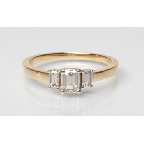 172 - A THREE STONE DIAMOND RING, the three graduated baguettes claw set to a plain 18ct gold shank, size ... 