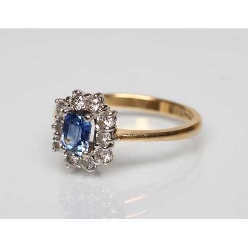 175 - A SAPPHIRE AND DIAMOND CLUSTER RING, the square cut sapphire claw set to a border of ten small round... 