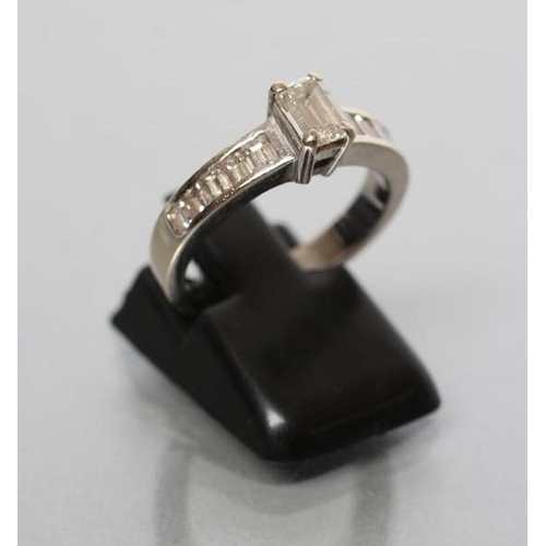 179 - A DIAMOND RING, the baguette cut central stone of approximately 0.30cts, claw set to shoulders each ... 