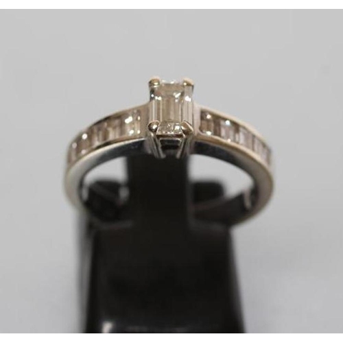 179 - A DIAMOND RING, the baguette cut central stone of approximately 0.30cts, claw set to shoulders each ... 