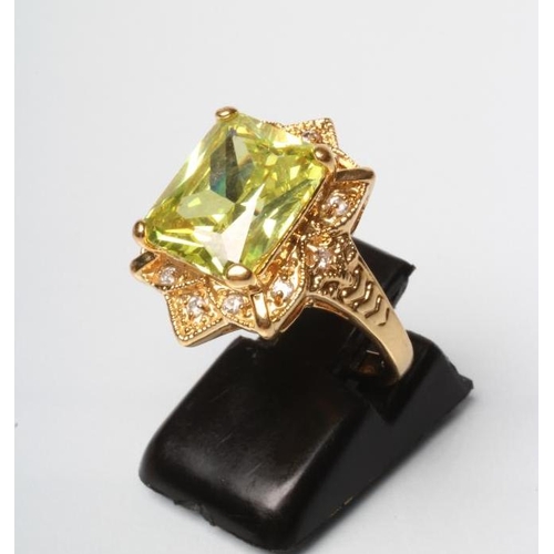 180 - A COCKTAIL RING, the square cut green stone claw set to a solid border set with twelve small diamond... 