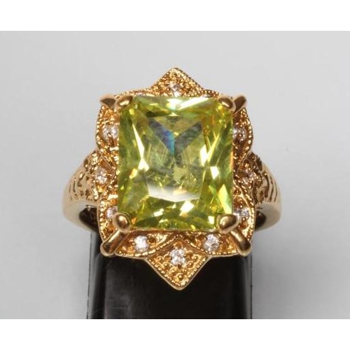 180 - A COCKTAIL RING, the square cut green stone claw set to a solid border set with twelve small diamond... 