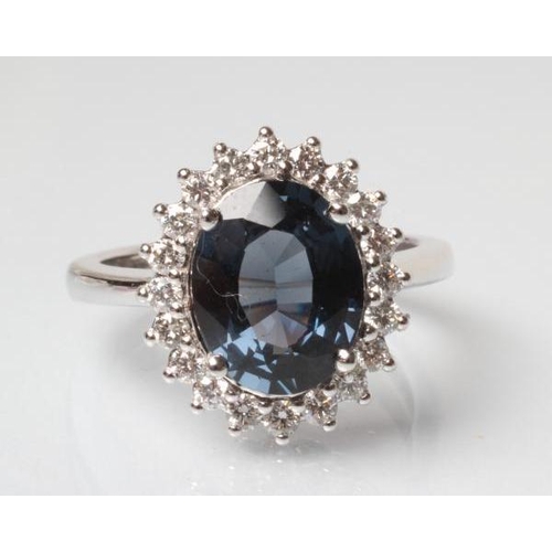 181 - A SAPPHIRE AND DIAMOND CLUSTER RING, the oval facet cut sapphire of 2.91cts, claw set to a border of... 