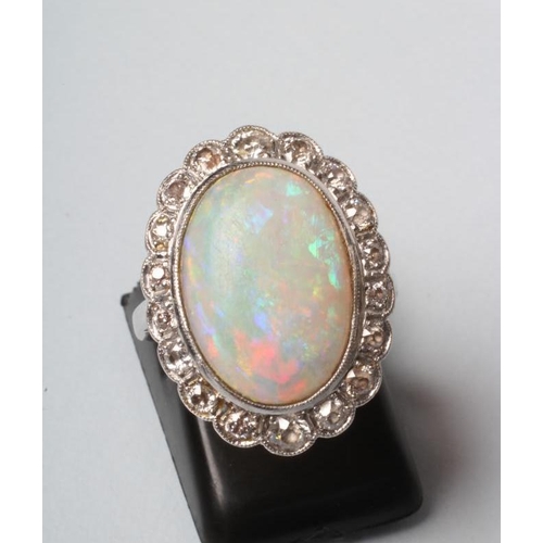 184 - AN OPAL AND DIAMOND CLUSTER DRESS RING, the oval cabochon polished pale opal open back collet set to... 