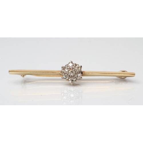 188 - A DIAMOND TIE PIN, the unmarked knife edge bar centred by a seven stone point set cluster, 1 1/2