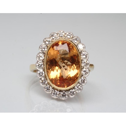 194 - A CITRINE AND DIAMOND DRESS RING, the oval facet cut citrine of approximately 7.5cts, open back coll... 