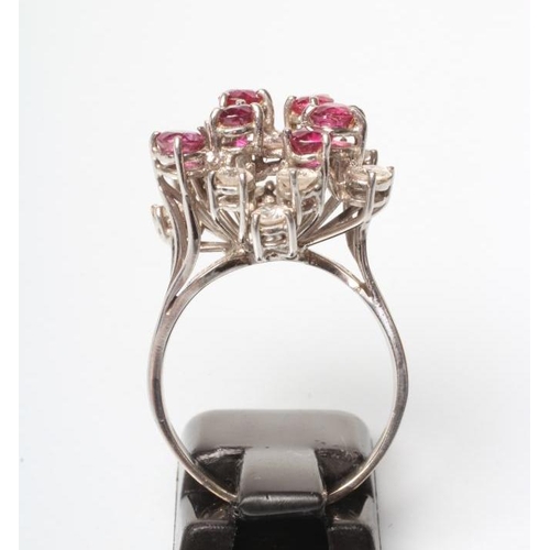 202 - A RUBY AND DIAMOND COCKTAIL RING, the open starburst claw set with six facet cut rubies and twelve b... 