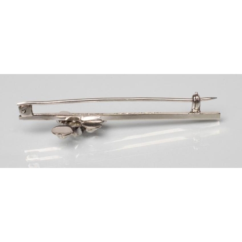 203 - A DIAMOND AND PEARL BAR BROOCH, the old facet cut oval diamond open back collet set to a clover leaf... 