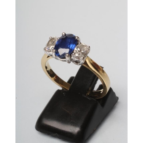 207 - A SAPPHIRE AND DIAMOND THREE STONE RING, the central oval facet cut sapphire claw set and flanked by... 