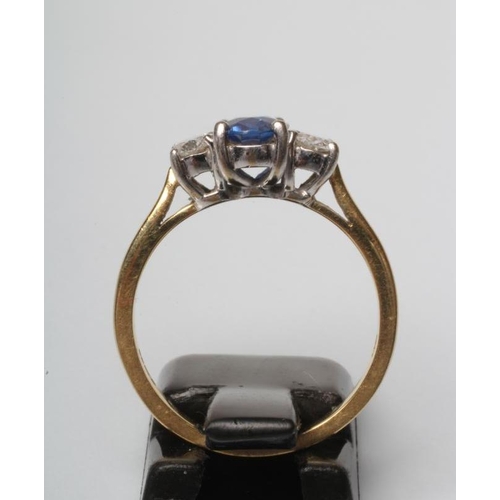 207 - A SAPPHIRE AND DIAMOND THREE STONE RING, the central oval facet cut sapphire claw set and flanked by... 