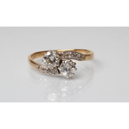 209 - A TWO STONE DIAMOND CROSSOVER RING, the round cut stones each of approximately 0.5cts claw set to di... 