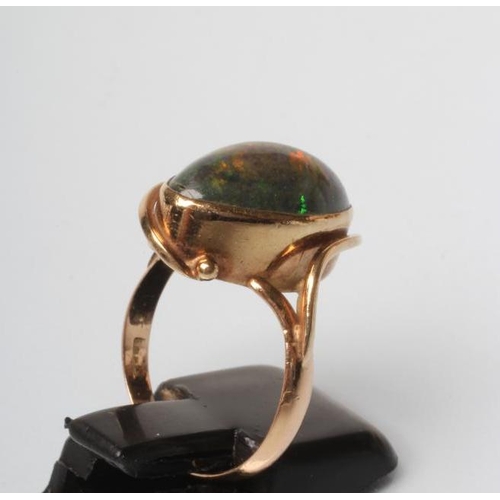 216 - AN OPAL RING, the oval cabochon polished green stone in an art nouveau style rub-over setting to a p... 