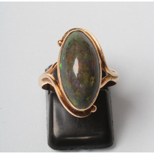 216 - AN OPAL RING, the oval cabochon polished green stone in an art nouveau style rub-over setting to a p... 