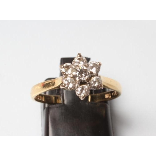 220 - A DIAMOND CLUSTER RING, the seven round brilliant cut stones claw set in a flowerhead to a plain 18c... 