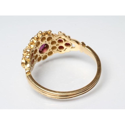 221 - A RUBY AND DIAMOND CLUSTER DRESS RING, the central facet cut ruby within a border of ten round brill... 