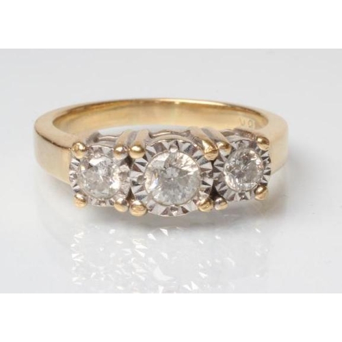 228 - A THREE STONE DIAMOND RING, the central round brilliant cut stone illusion set in a fluted border an... 